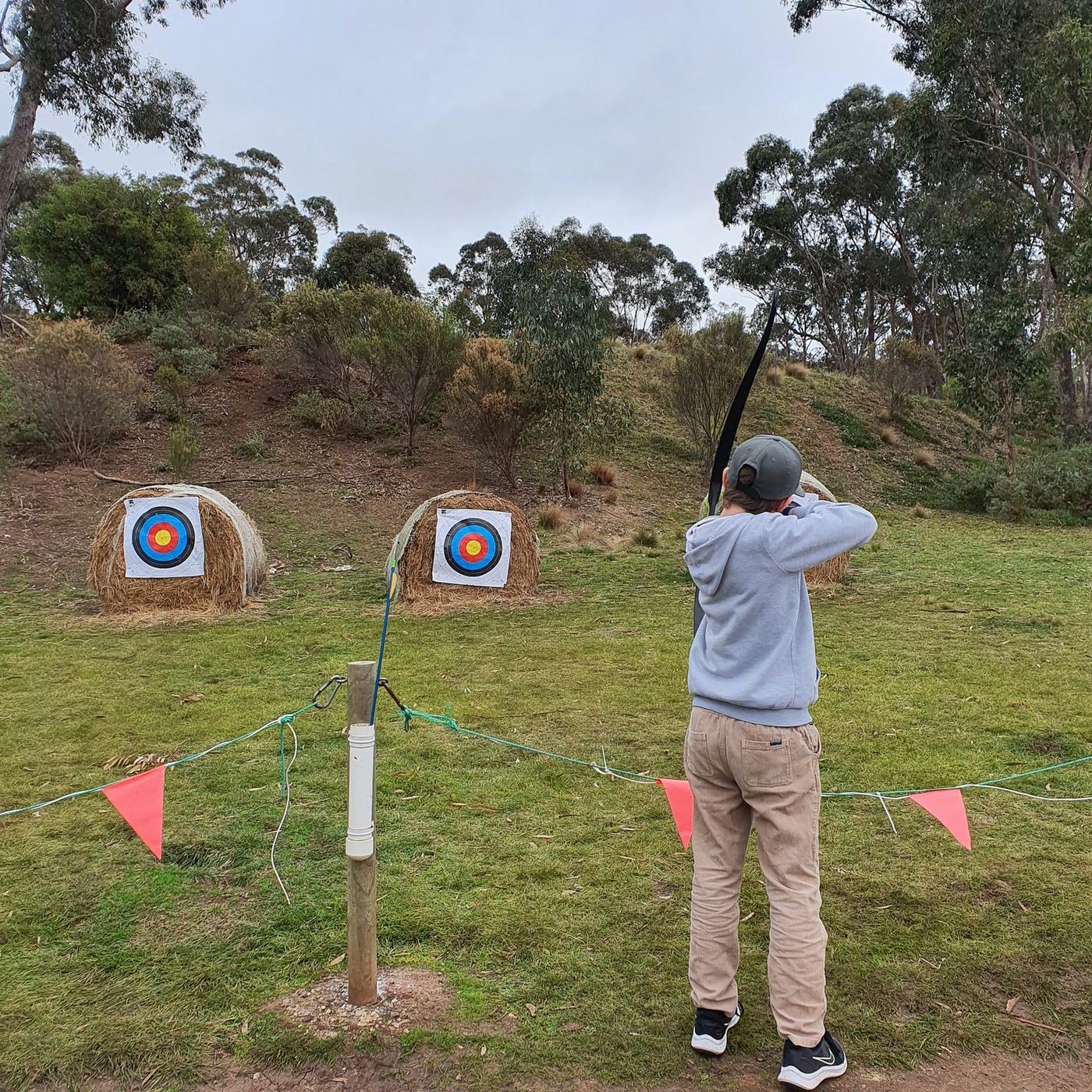 An adult drawing a bow at the Sunnystones archery range