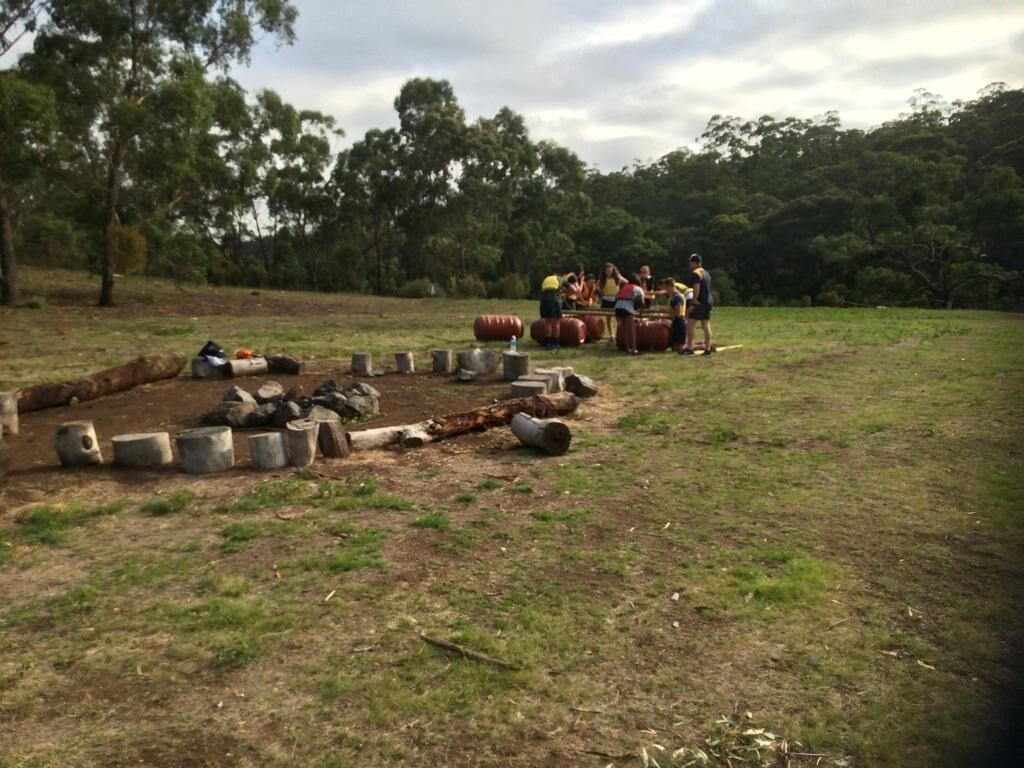 A group gathered around the fire circle in the paddock