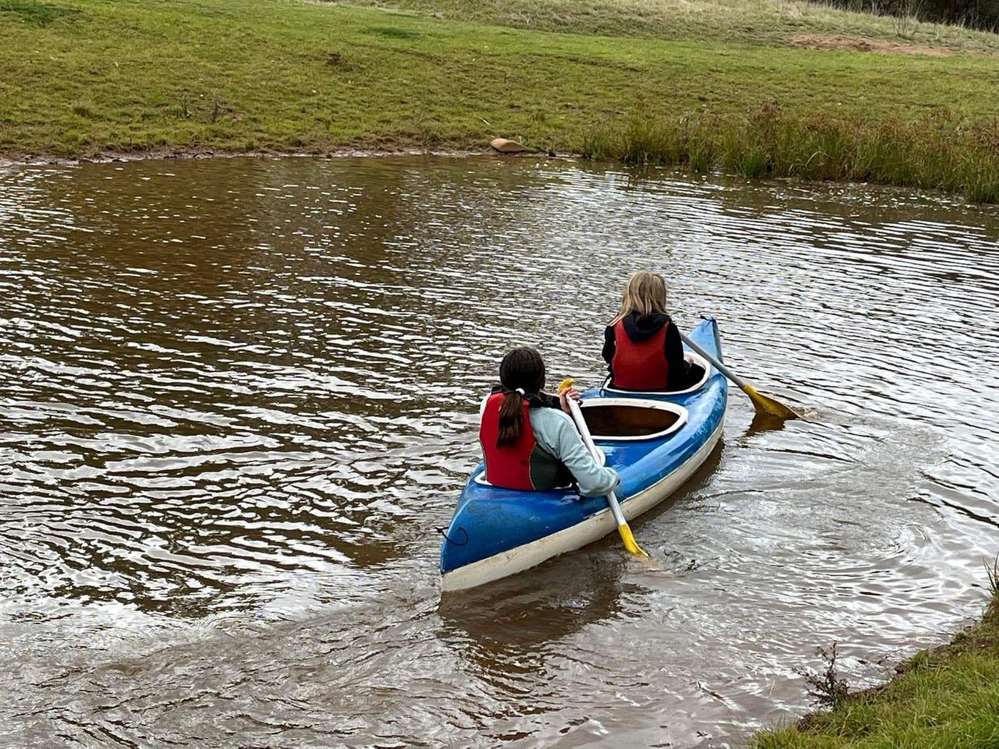 Two students paddling a canoe on the Sunnystones dam