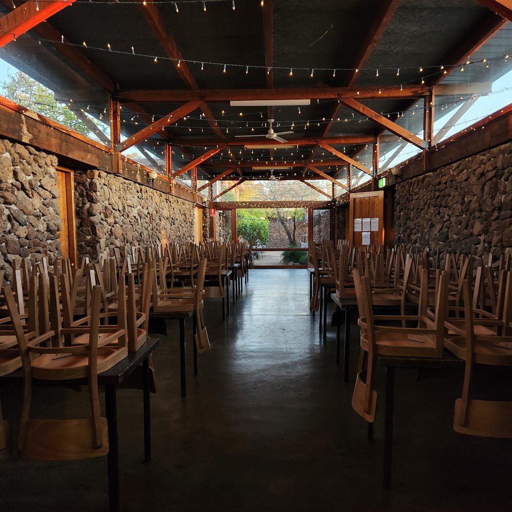 The 26-metre Homestead Hall, a long stone dining room under timber trusses and festoon lights