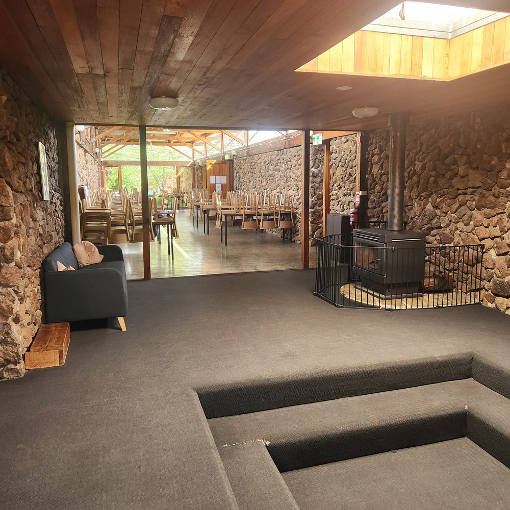 The sunken lounge with its wood heater, looking through to the dining hall