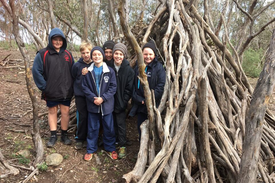A proud team beside their finished bush hut