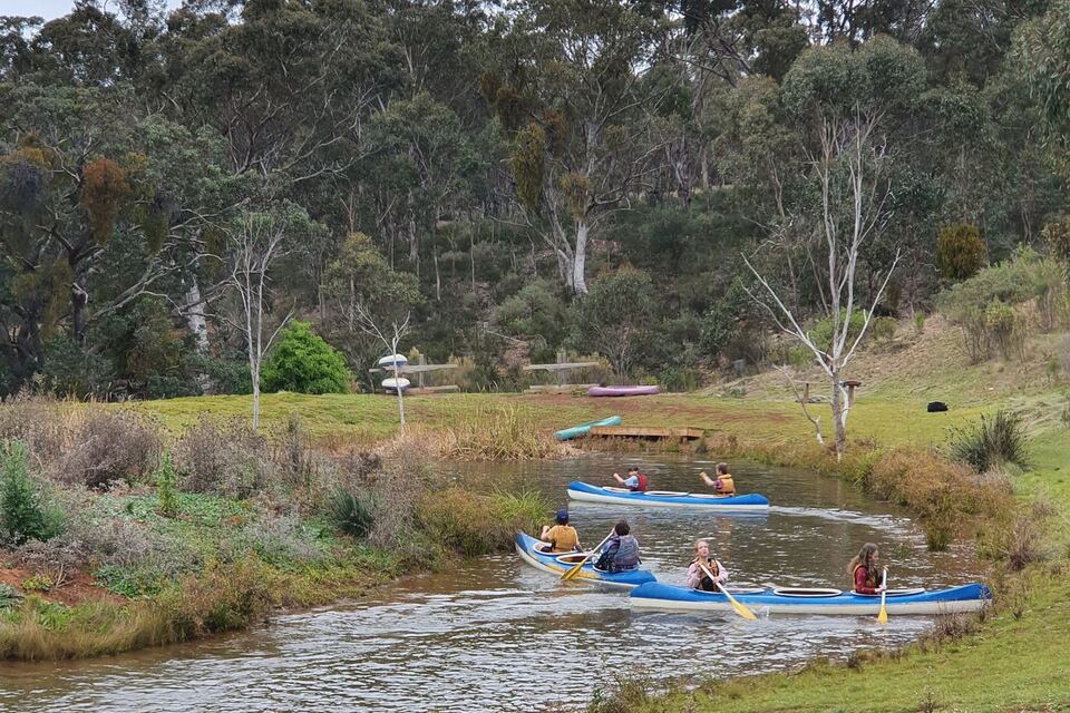 Canoes weaving along the water between the banks