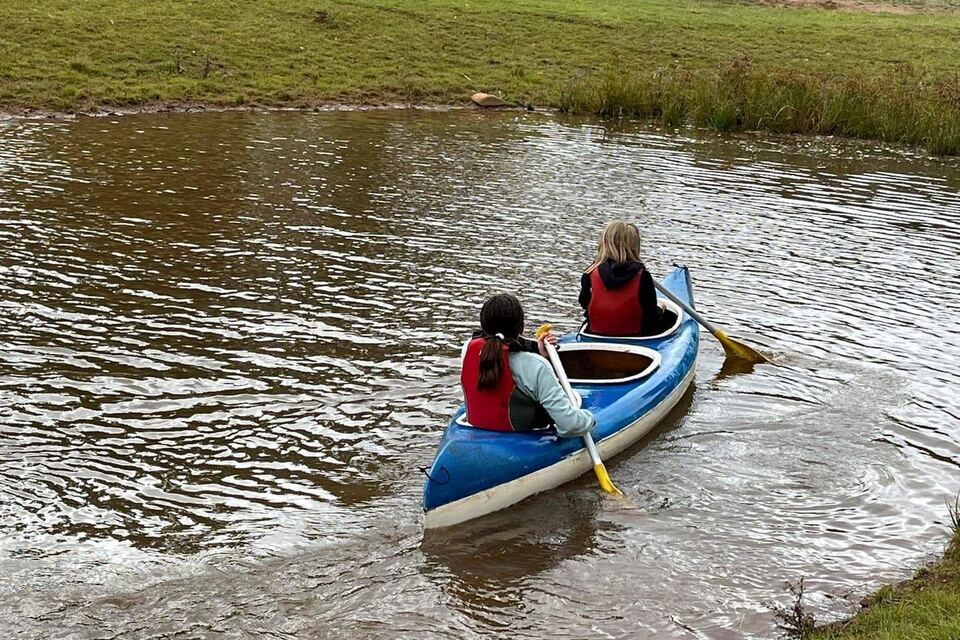Two students paddling a canoe