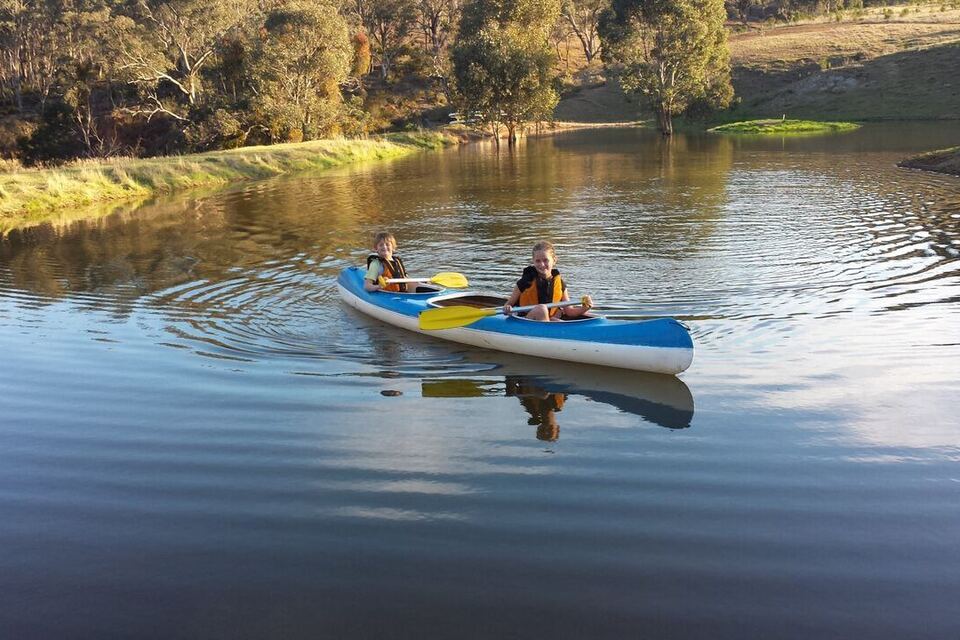 A canoe gliding across the still dam