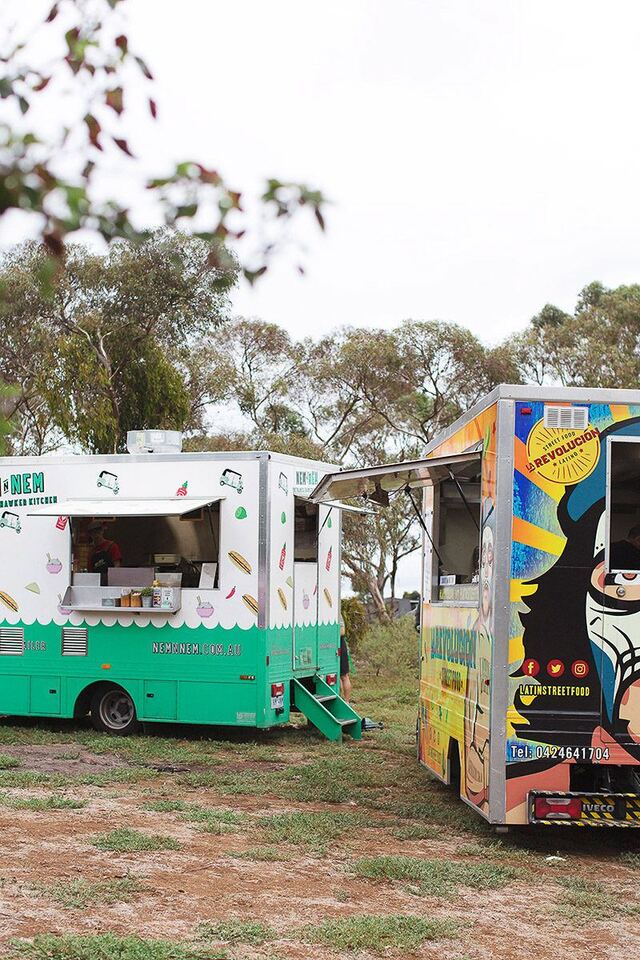 Food trucks serving guests among the gums