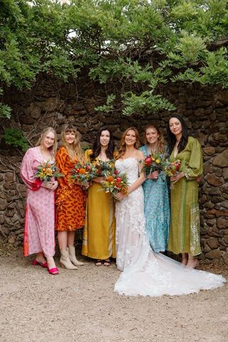 The bride with her bridesmaids in colourful mismatched dresses