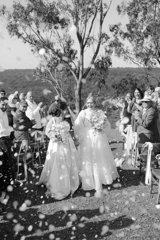 A black-and-white confetti moment as guests celebrate the newlyweds