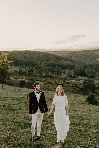 A couple walking hand in hand across the valley at dusk
