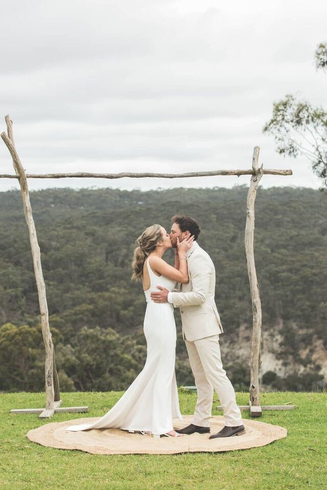 A couple kissing beneath a timber arbour on the lower terrace