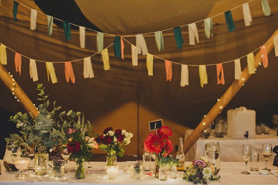 Tipi reception with bunting and flowers